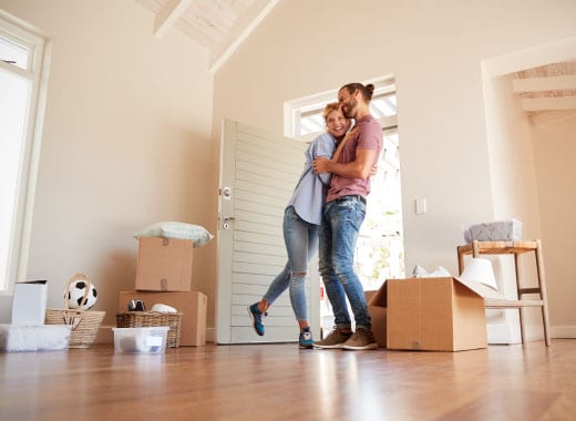 mortgage-broker-palmbeach couple hugging in new home